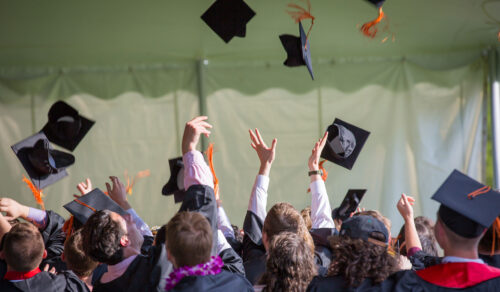 Glenelg High School students throw graduation caps in the air